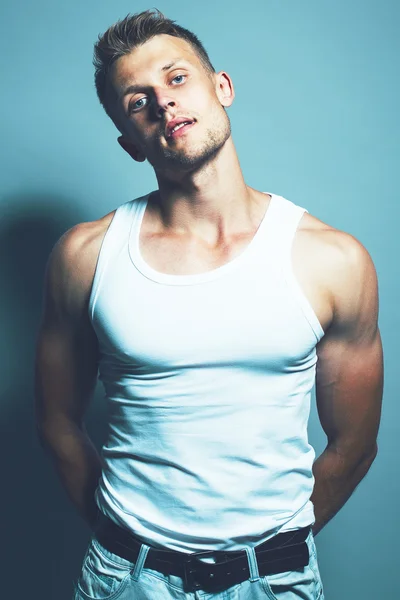 Bello muscoloso giovane uomo in maglietta bianca, luce je — Foto Stock
