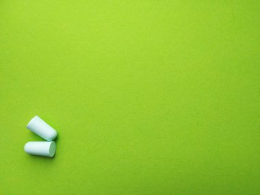 Yeşil arka planda açık yeşil kulak tıkaçları