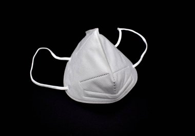 Tek kullanımlık KN-95 maskesi ya da beyaz renkli yeni tıbbi maske. COVID-19 önleme. H1N1, H5N1 güvenlik önlemleri. Siyah arkaplanda izole.