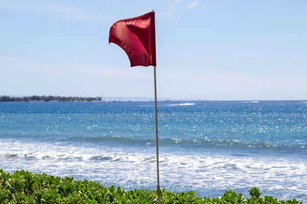 Červená vlajka na pláži — Stock fotografie