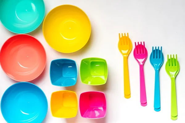 Bright colorful plastic disposable tableware on white background