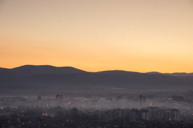 Yumuşak, sisli, puslu Pirot şehri sonbaharda gece boyunca uzak ufuk dağları ve renkli altın ve mavi gökyüzü