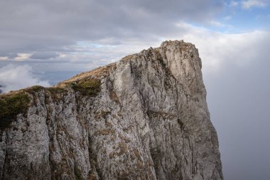 Kuru Dağ 'da (Suva planina) kayalık, dik kayalık, sonbaharda kuru, turuncu çimlerle kaplı ve bulutlu mavi gökyüzü