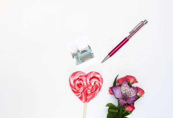 Composición con cosméticos de maquillaje, bolígrafo, tarjeta y flores sobre fondo blanco Fotos De Stock