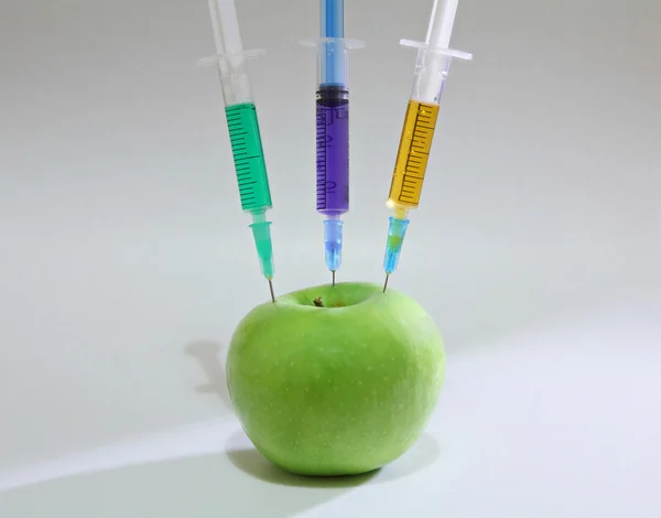 Green apple with syringes — Stock Photo, Image