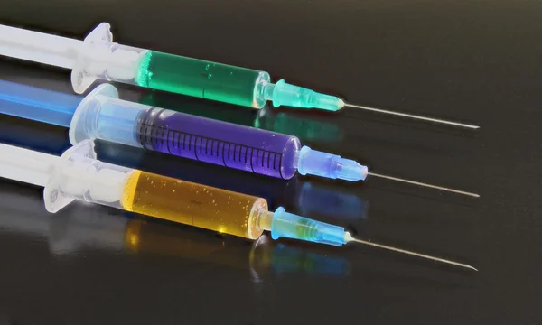 Three syringes on the black background — Stock Photo, Image