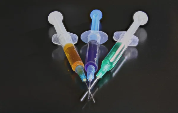 Three syringes on the black background — Stock Photo, Image