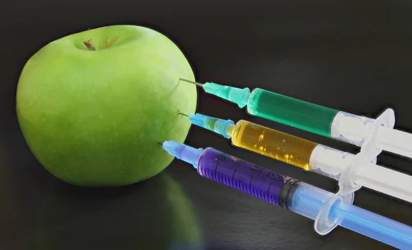 Grüner Apfel mit Spritzen lizenzfreie Stockfotos