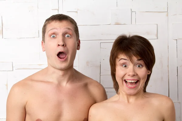 Young couple with emotions of wonder near the white wall — Stock Photo, Image