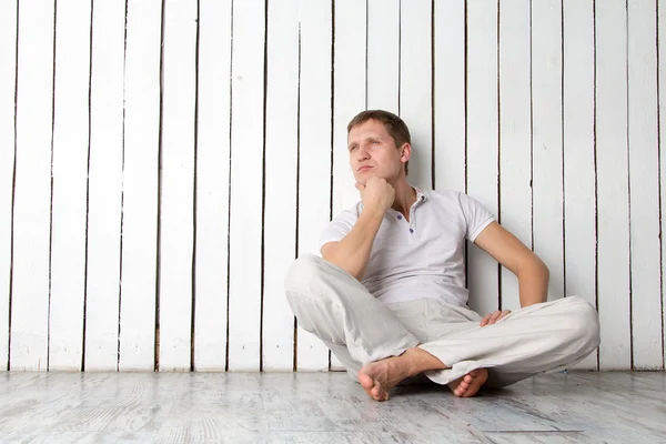 Duvara yakın oturan adam