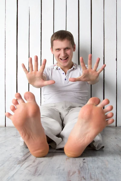 Adam gülümseyen duvara yakın oturan parmak gösterir