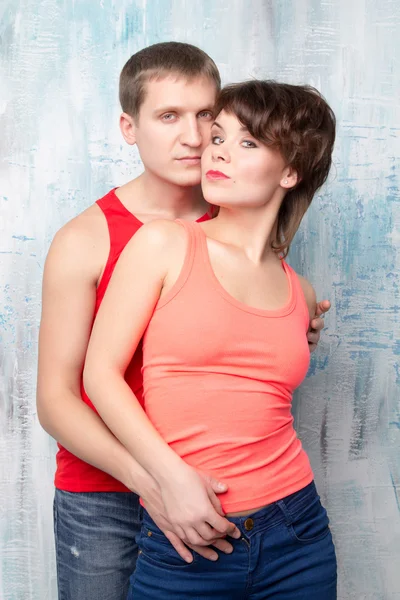 Young couple in red t-shirts near the wall — Stock Photo, Image