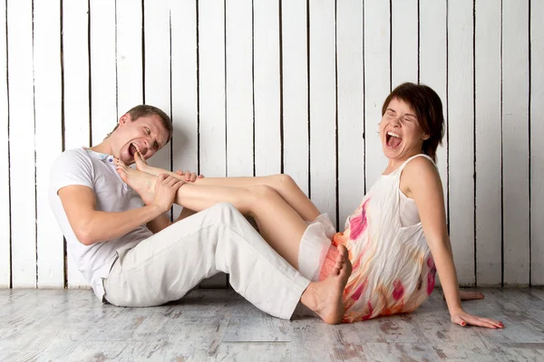 Genç bir çift Beyaz ahşap duvara yakın ısırıyor