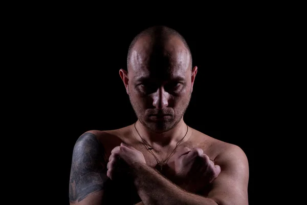 Silhouette of serious man with crossed hands and tattoo — Stock Photo, Image