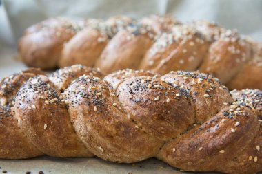 Geleneksel fırınlanmış Challah ekmeği, hecelenmiş undan yapılmış, susam ve haşhaş tohumlu.