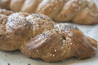 Geleneksel fırınlanmış Challah ekmeği, hecelenmiş undan yapılmış, susam ve haşhaş tohumlu.