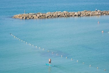 Akdeniz 'in sularında sörf yapan bir adam (Standup paddleboard), Tel Aviv, İsrail
