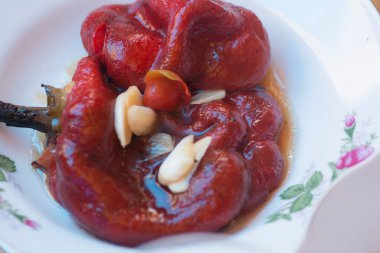 Sarımsaklı bir tabakta servis edilen Romen dolma biberi turşusu