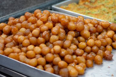 Awamat tatlıları yığını, Lokmet El Kady olarak da bilinir, ve Lokaymat, Lübnan gevrek donut topları, şurupla kaplıdır.