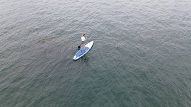 Dağ gölünde kürek çeken yalnız kadın