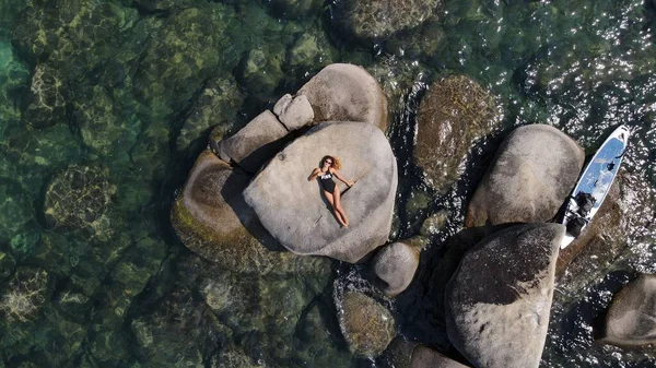 Любители отдыхают на скалах озера на диком пляже — стоковое фото