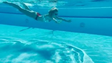 Yavaş çekim, su altında yüzen güzel genç bayan. 