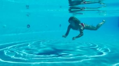 Tatlı genç bayan suyun altında yüzüyor. 