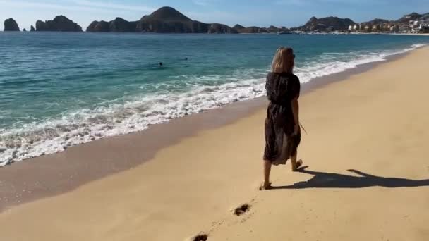 Pieds nus marchant le long de la plage de sable doré — Video