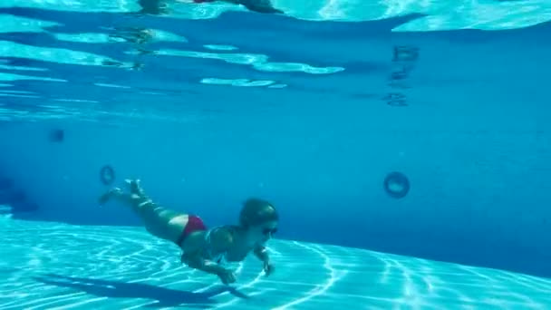 Beautiful young lady deep swimming underwater — Stock Video