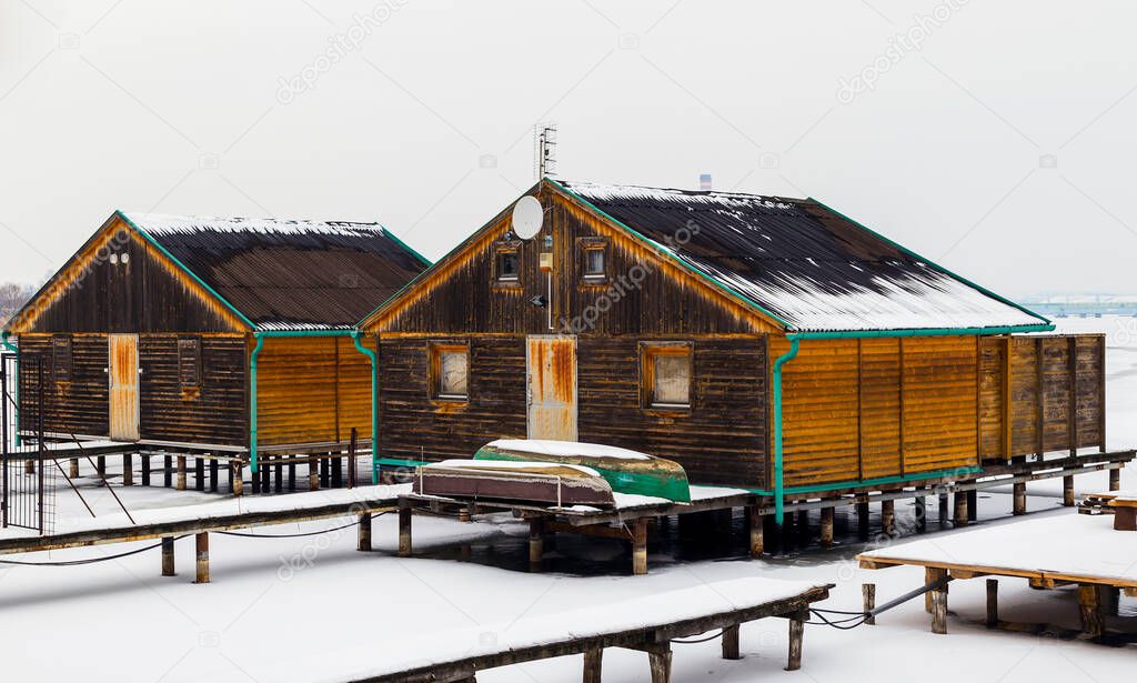 Fishing huts and boats on the jetty at winter.Floating village, Bokod, Hungary.