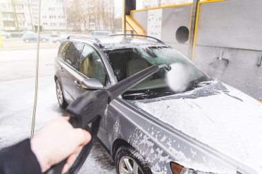 Bağlantısız oto yıkama sistemi. Araba yıkama istasyonunda köpükle kirli araba yıkamak.