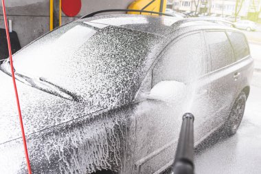 Bağlantısız oto yıkama sistemi. Araba yıkama istasyonunda köpükle kirli araba yıkamak.