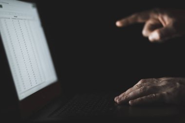 Dizüstü bilgisayarda klavye kullanan bir adam. İnsan ekranı işaret ediyor. Ellerin ve klavyenin yakın çekim görüntüsü