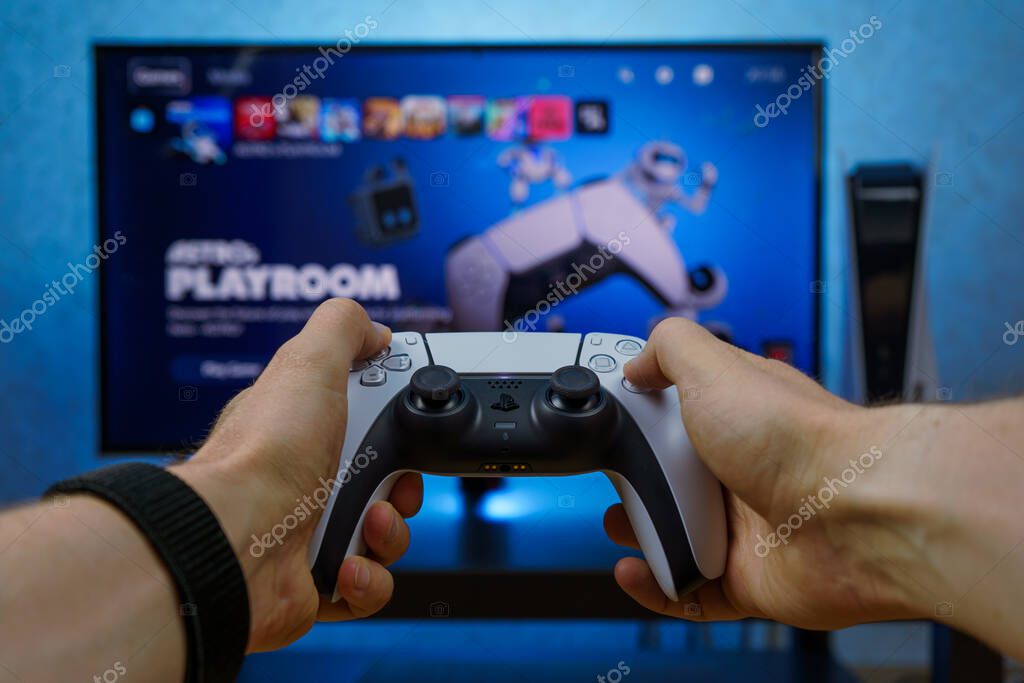 Sony PlayStation 5. New generation gaming computer. PS5 controller. Man playing video games