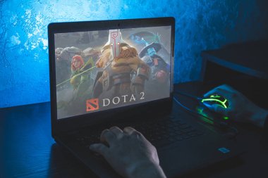 Dota 2, çok oyunculu bir online savaş arenası video oyunudur. Bilgisayar oyunu. Adam dizüstü bilgisayarda video oyunu oynuyor