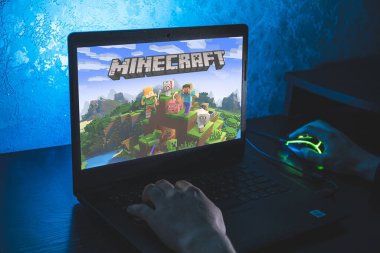 Minecraft bir kum havuzu video oyunudur. Bilgisayar oyunu. Adam dizüstü bilgisayarda video oyunu oynuyor