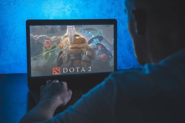 Dota 2, çok oyunculu bir online savaş arenası video oyunudur. Bilgisayar oyunu. Adam dizüstü bilgisayarda video oyunu oynuyor