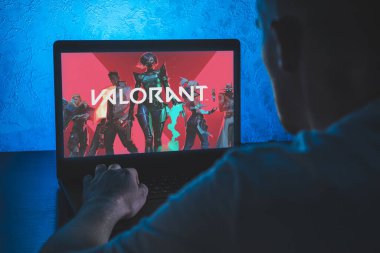 Valorant çevrimiçi kahraman vurucu serbest oyuncu. Bilgisayar oyunu. Adam dizüstü bilgisayarda video oyunu oynuyor