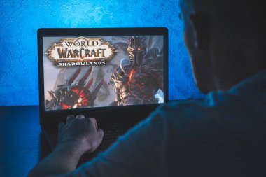 World of Warcraft çok oyunculu çevrimiçi bir rol yapma oyunudur. Bilgisayar oyunu. Adam dizüstü bilgisayarda video oyunu oynuyor