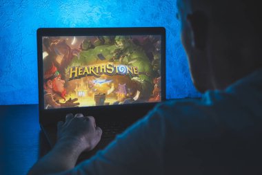 Hearthstone çevrimiçi dijital koleksiyon kartı oyunu. Bilgisayar oyunu. Adam dizüstü bilgisayarda video oyunu oynuyor