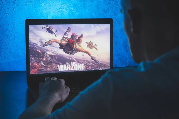 Call of Duty: Warzone, Royale 'de oynanan ücretsiz bir savaş oyunudur. Bilgisayar oyunu. Adam dizüstü bilgisayarda video oyunu oynuyor