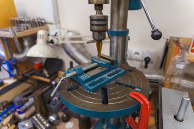 Bir atölyede matkap ucu ve mavi mengene ile profesyonel matkap presi. Yüksek kalite fotoğraf