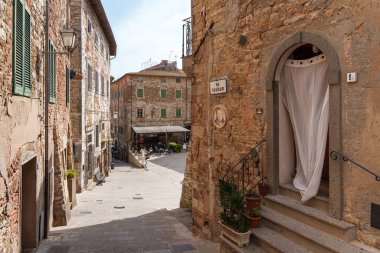 Campiglia Marittima 'daki dar eski cadde, Tuscany, İtalya' da tarihi mimarisi ve taş binaları olan büyüleyici bir ortaçağ köyü. 12 Haziran 2025