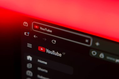 YouTube logosunu ve ev menüsünü canlı bir kırmızı ışıklandırma efektiyle, çevrimiçi video yayını, içerik oluşturma ve dijital medyayı temsil eden karanlık bir arayüzde gösteren bir web tarayıcısını kapatın. Yüksek kalite fotoğraf