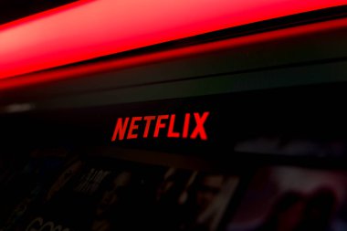 Çevrimiçi video eğlencesini temsil eden canlı kırmızı ışıklandırma ile resmi kırmızı logoyu içeren bir bilgisayar ekranındaki Netflix yayın servis arayüzünü kapatın. Yüksek kalite fotoğraf