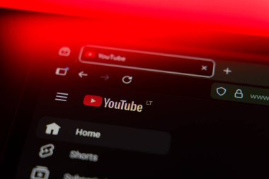 YouTube logosunu ve ev menüsünü canlı bir kırmızı ışıklandırma efektiyle, çevrimiçi video yayını, içerik oluşturma ve dijital medyayı temsil eden karanlık bir arayüzde gösteren bir web tarayıcısını kapatın. Yüksek kalite fotoğraf