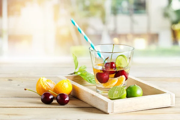 健康排毒水，樱桃、 橙汁和青柠木托盘上的玻璃 — 图库照片