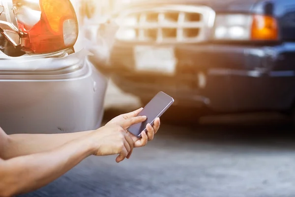 Araba kazasından sonra yol kenarında Smartphone kullanan adam Telifsiz Stok Imajlar