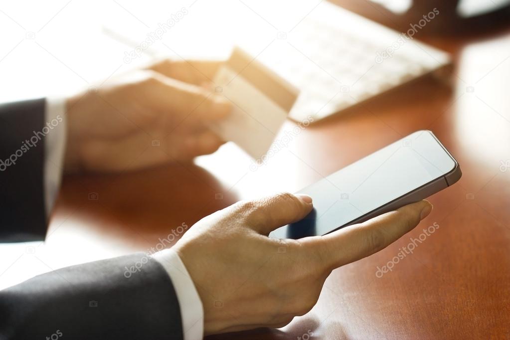 Mobile payments, businessman using smartphone and credit card
