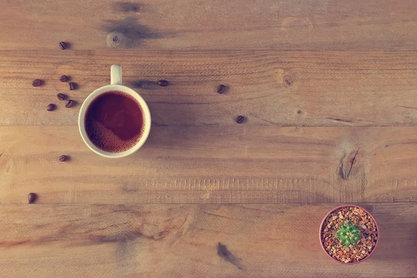 Tazza di caffè e cactus in vaso su legno, Vista dall'alto — Foto Stock